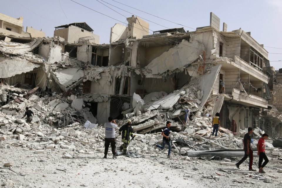 People inspect a damaged site after airstrikes on the rebel held al-Qaterji neighbourhood of Aleppo