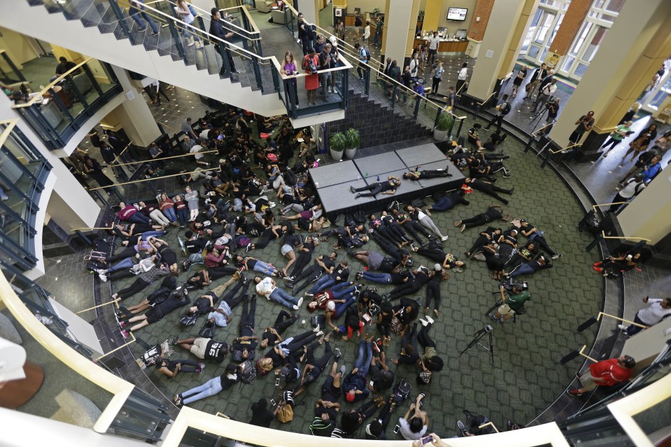 Students at the University of North Carolina Charlotte hold a vigil by lying on the floor of the student union following Tuesday's fatal police shooting of Keith Scott