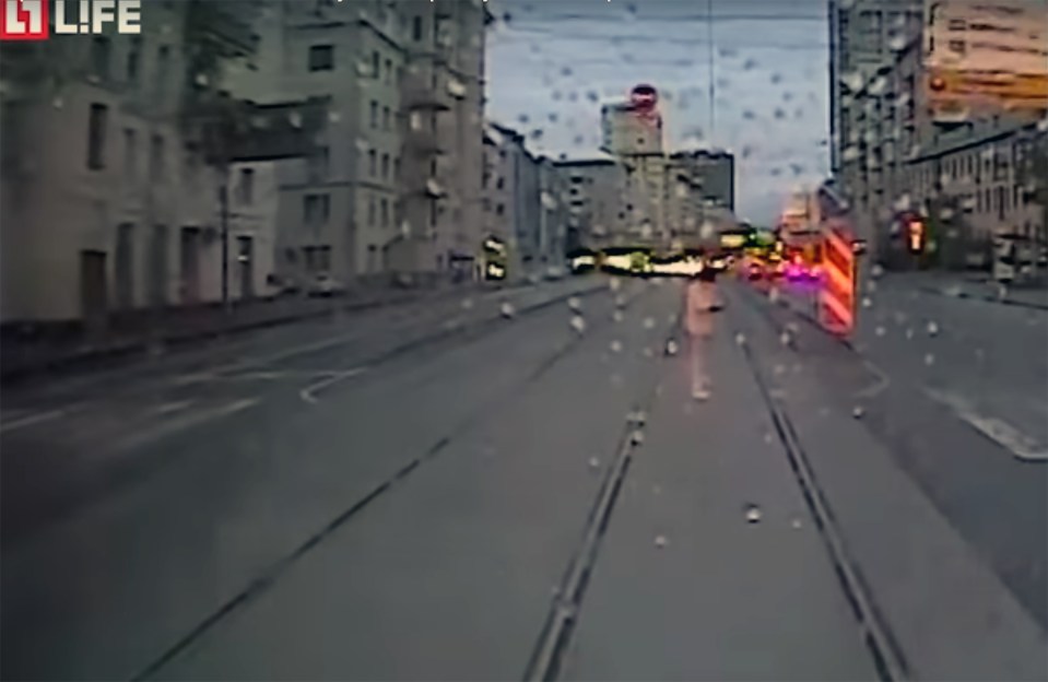 The view of the woman is at first obscured by the rain in the footage