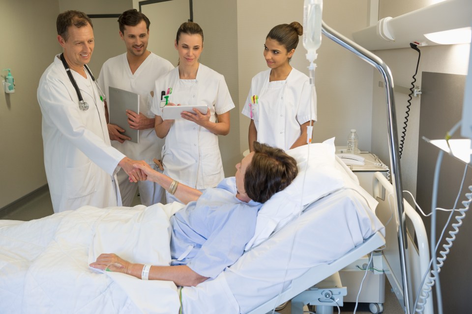 Medical team attending female patient on hospital bed
