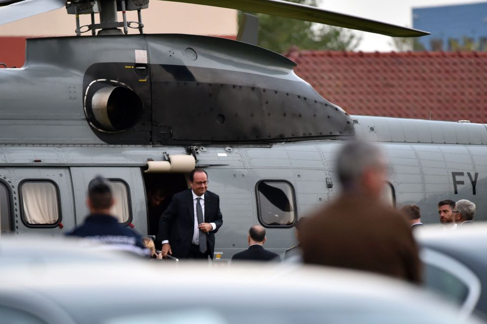 French President Francois Hollande gets off a helicopter for his visit to Calais port in the country's north