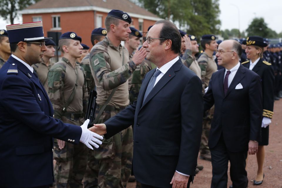 Hollande shakes hands with French Gendarmerie and soldiers during a visit to the Gendarmerie of Calais