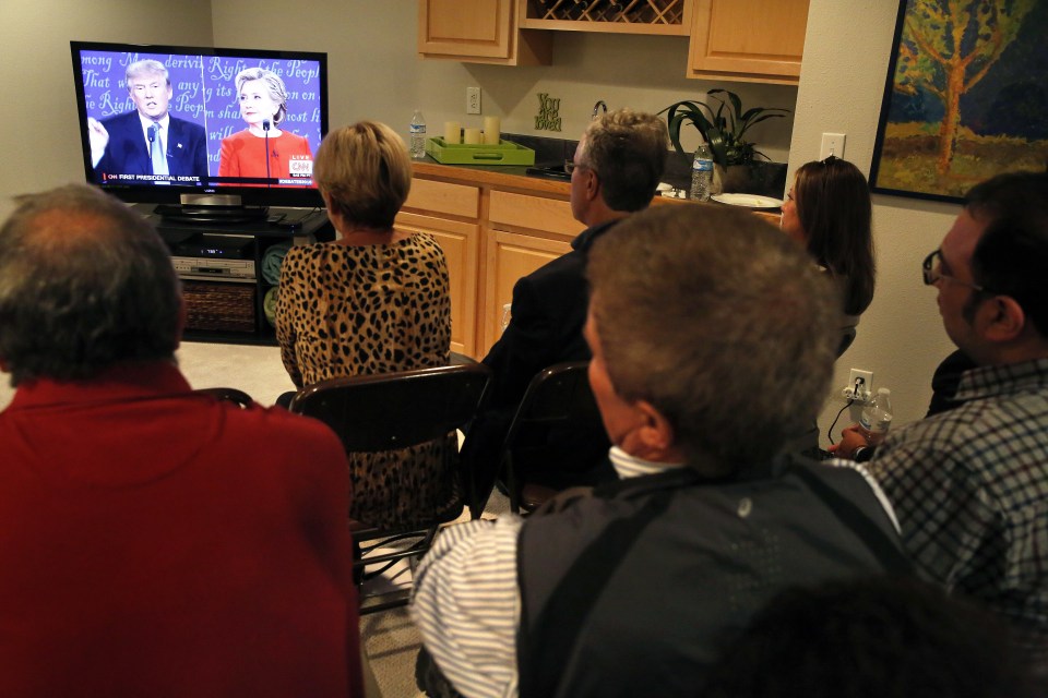 A group of friends and colleagues listen to the first presidential debate during a watch party at Swalm's house in Centennial, Colorado