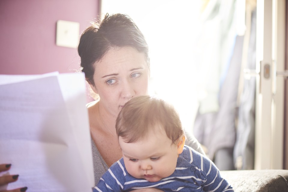 Mother sat with child worrying about her finances