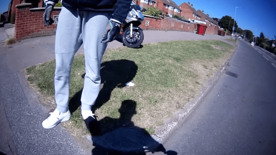 The motorcyclist gets off his bike, threatening the other cyclist as their argument gets even more heated