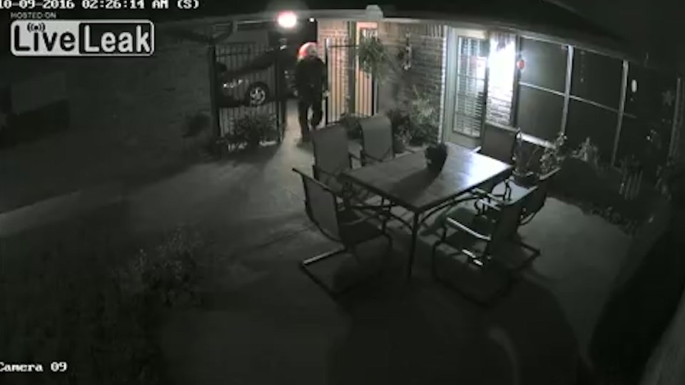 The footage cuts to colour with the clown's bright orange wig clearly visible