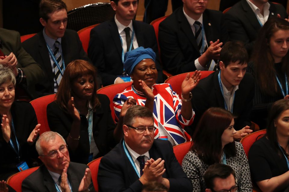 A patriotic supporter in a Union Jack outfit claps during the speech