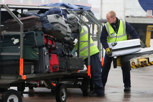 baggage handlers unloading plane at Manchester Airport