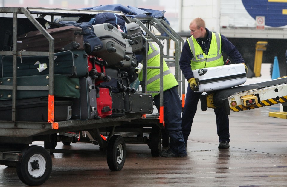 baggage handlers unloading plane at Manchester Airport