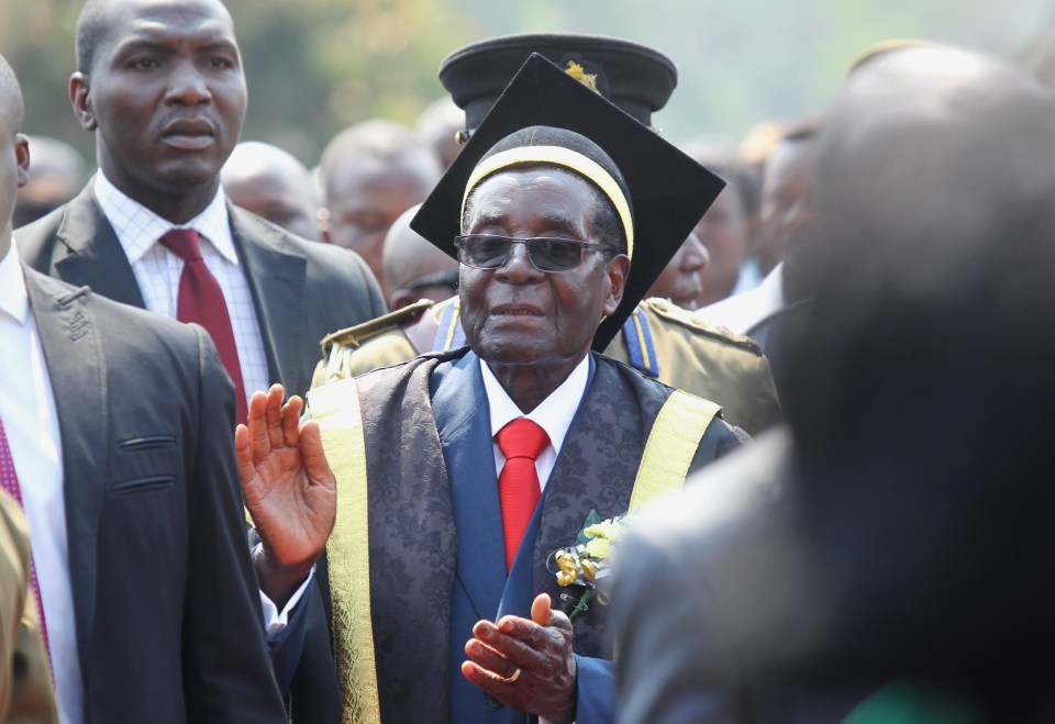 Zimbabwean President Robert Mugabe, centre, arrives at a graduation ceremony at the University of Zimbabwe