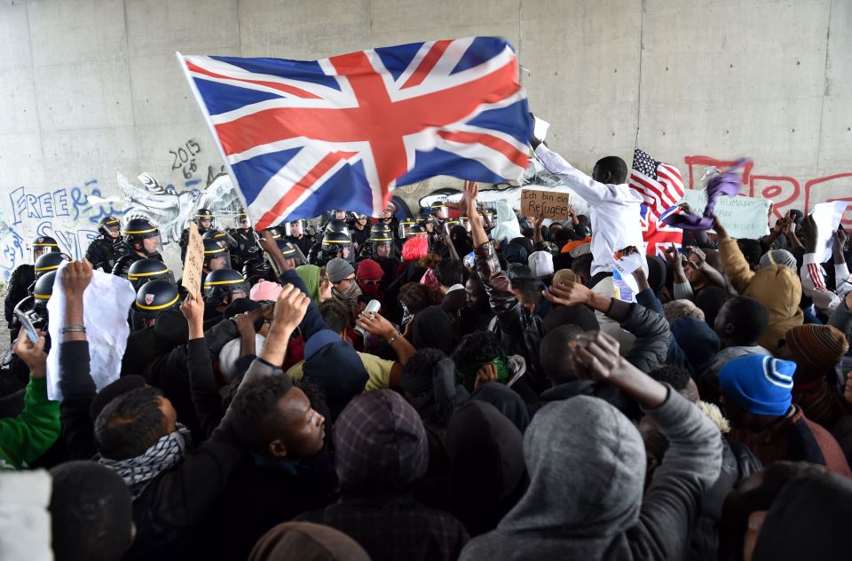 Protester waves the Union Jack flag in front of French anti-riot police