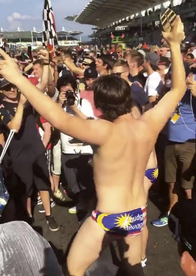 An Australian man dances in Budgy Smuggler-brand swimsuits decorated with the Malaysian flag at the conclusion of the Malaysian Formula One Grand Prix in Sepang