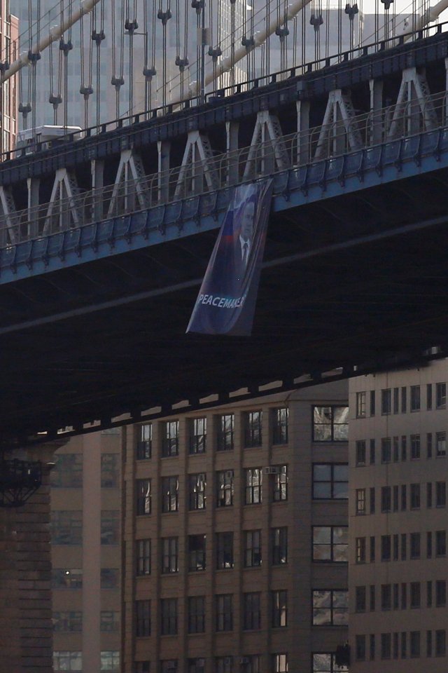 A banner with an image of Russian President Vladimir Putin hangs from the Manhattan Bridge in New York
