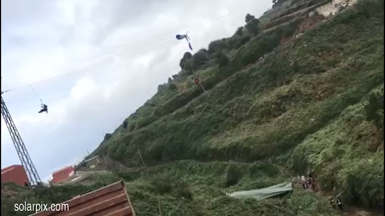 The man is seen dangling above the slope in the town