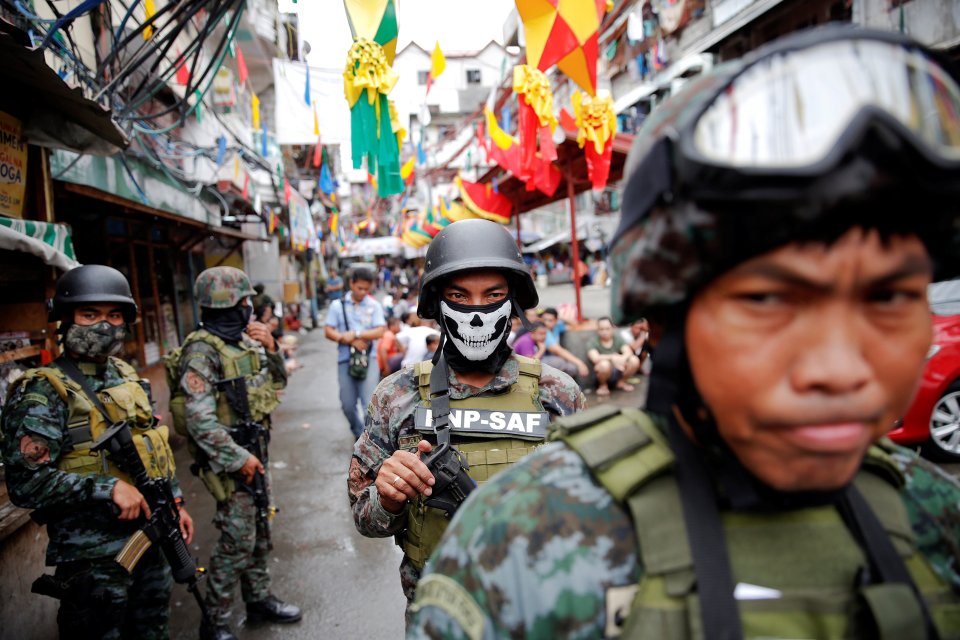 Armed security forces take a part in a drug raid, in Manila