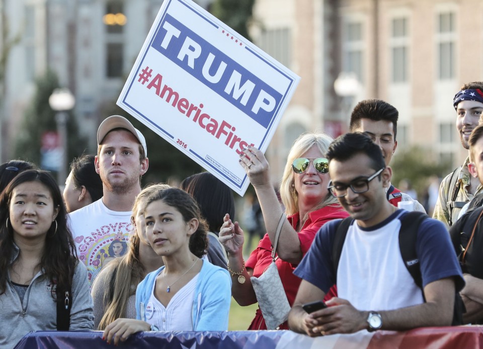 A supporter of Donald Trump holds a poster at a media booth before the presidential debate in Washington University in St. Louis, Missouri