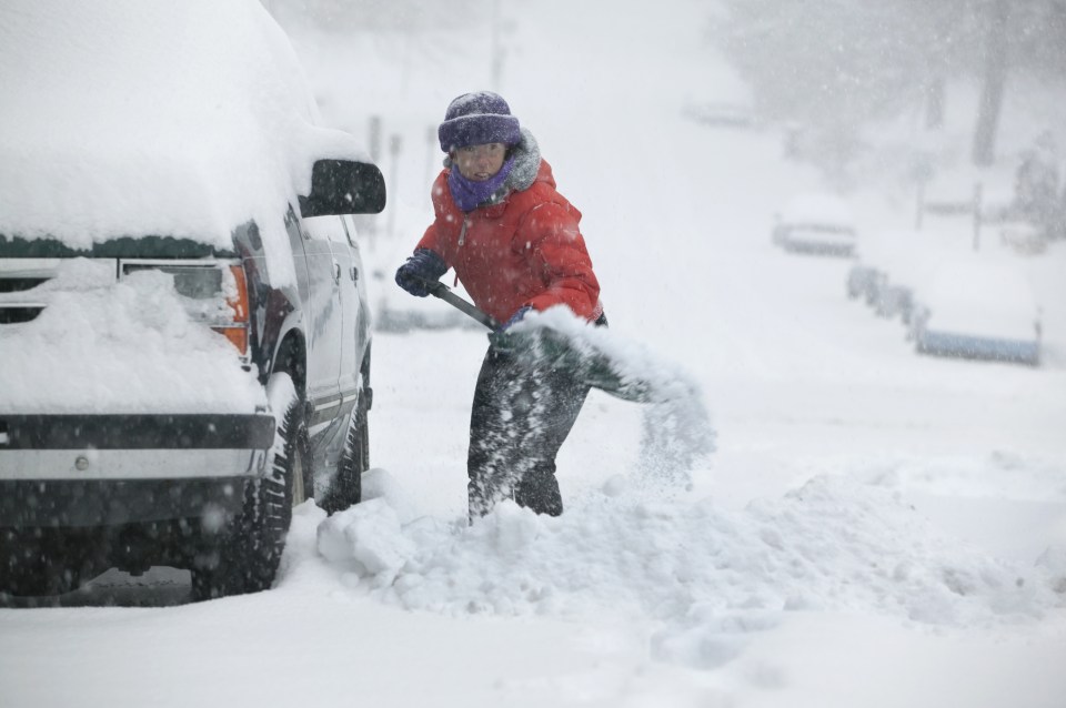 woman shovelling snow in snowstorm