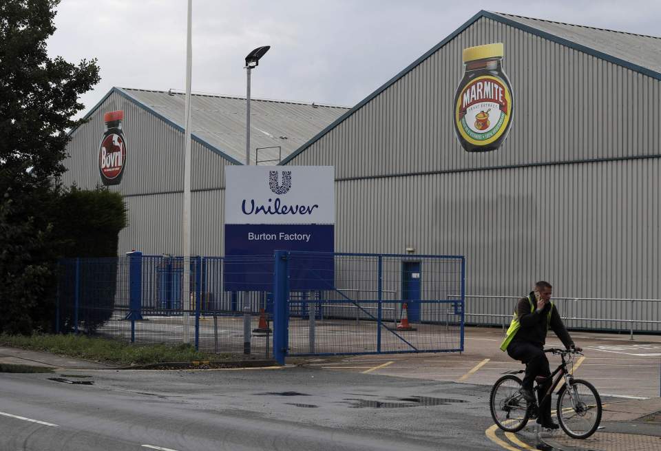 A man cycles past Unilever's Marmite factory in Burton upon Trent