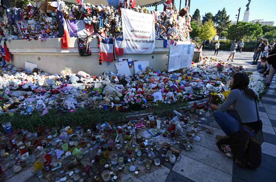 A woman looks at candles, toys and flowe