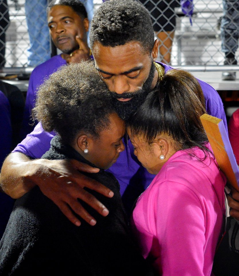 Tyson Gay embraces those gathered during a candlelight vigil at Lafayette High School for his daughter Trinity