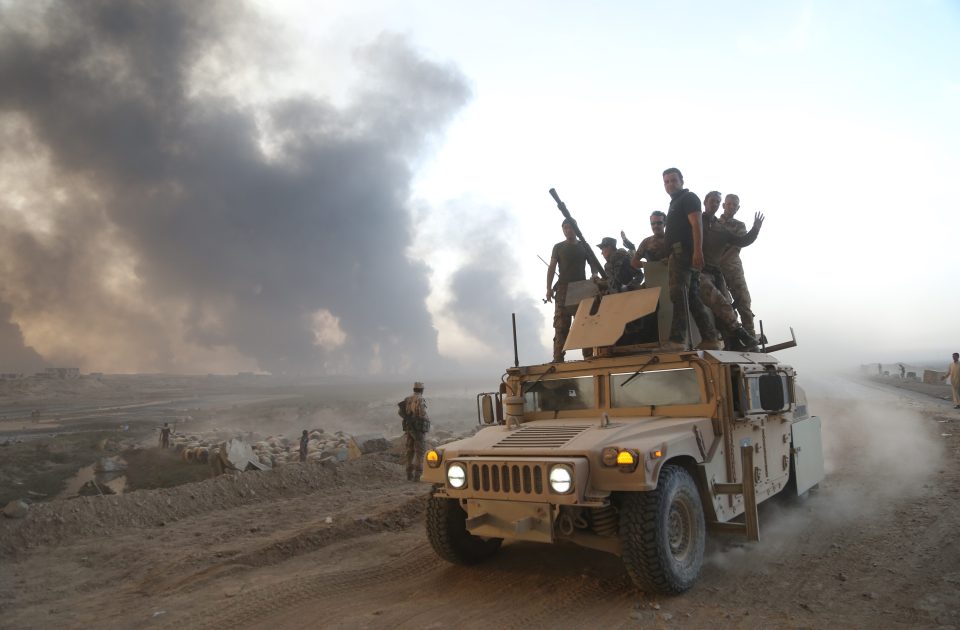 An Iraqi tank advances as the smoke from the burning oil wells blots the sky