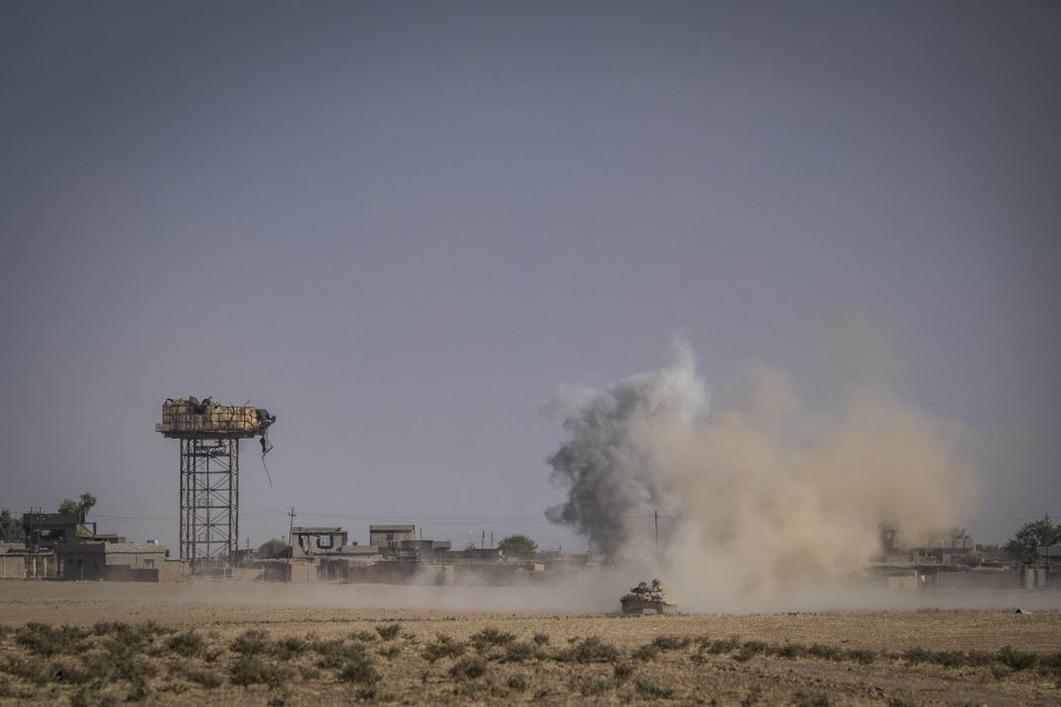 A tank rumbles through the outskirts of the city