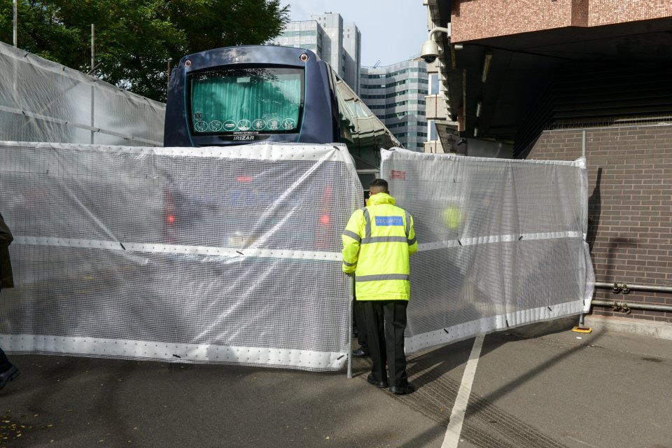A coachload of arriving migrants were shielded from view by the sheets
