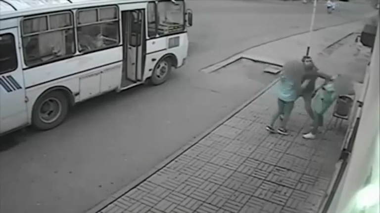 The thug strikes the terrified woman