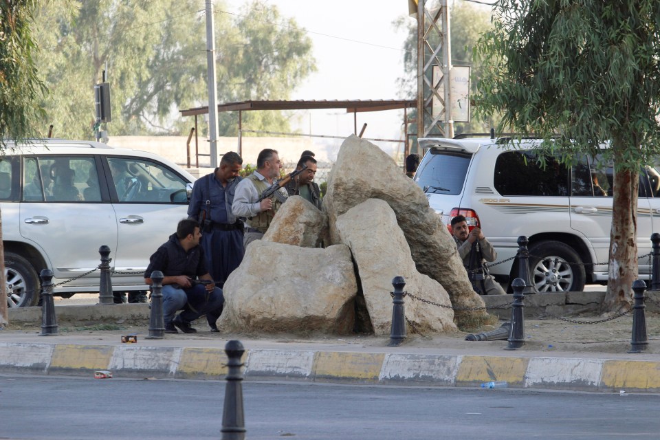 Peshmerga forces stand behind rocks during the Kirkuk battle