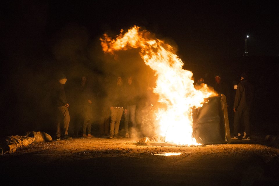 Migrants set rubbish bins alight last night as they clashed with cops