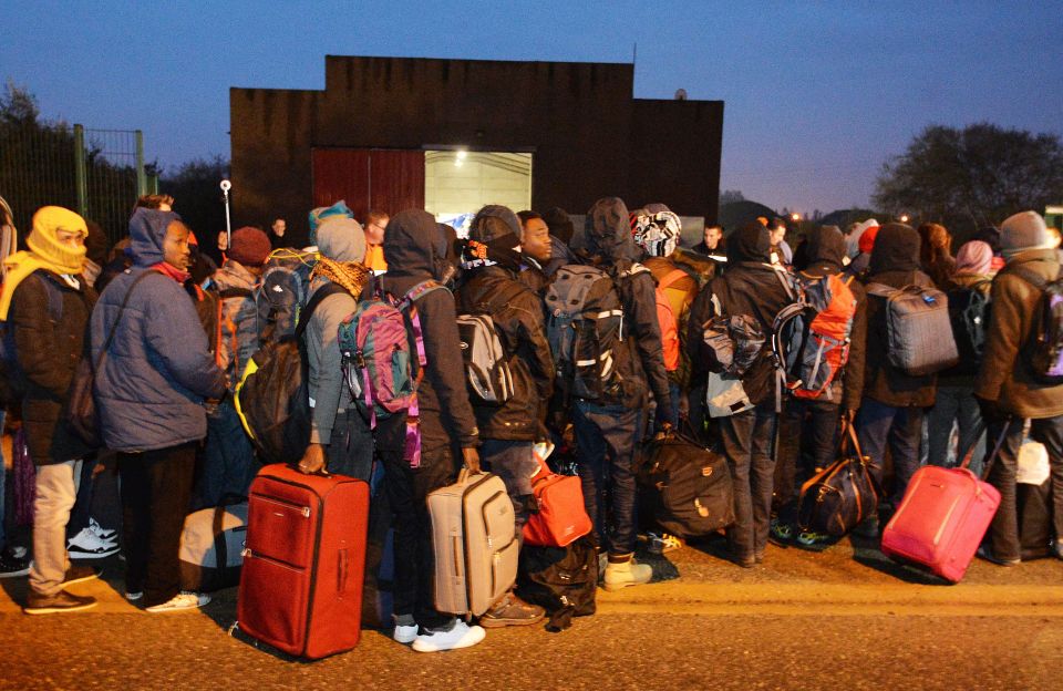 Migrants made their way to a temporary transport hub to be bussed to other parts of France
