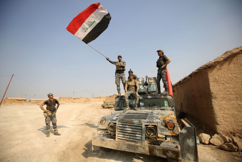  Iraqi government forces raise their national flag as they enter the village of al-Khuwayn, south of Mosul