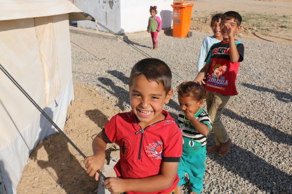 Refugees children smile for the cameras in Iraq's Dibaga refugee camp