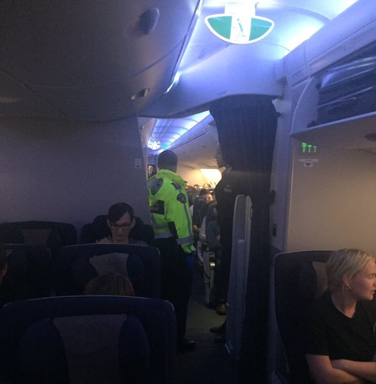 An officer is pictured on board the plane after it diverted to Vancouver