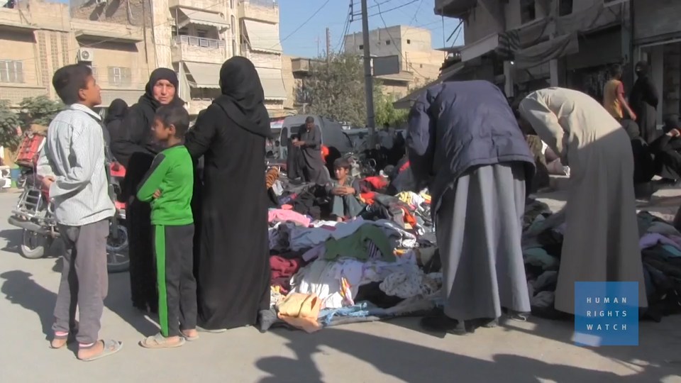 Grieving families stand around people killed by booby traps