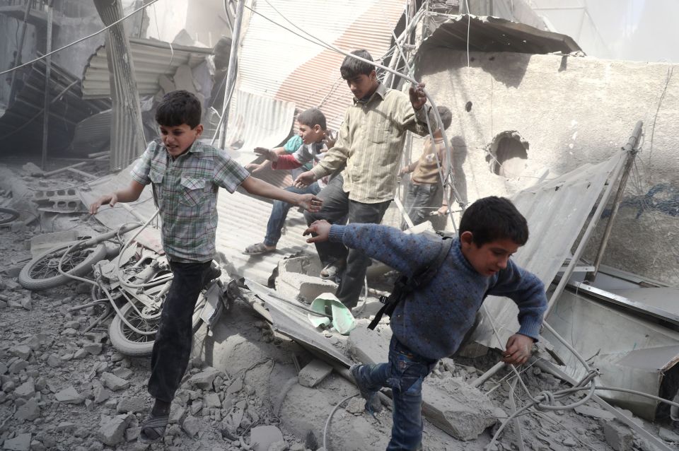 Syrian children running for cover in the aftermath of the airstrikes