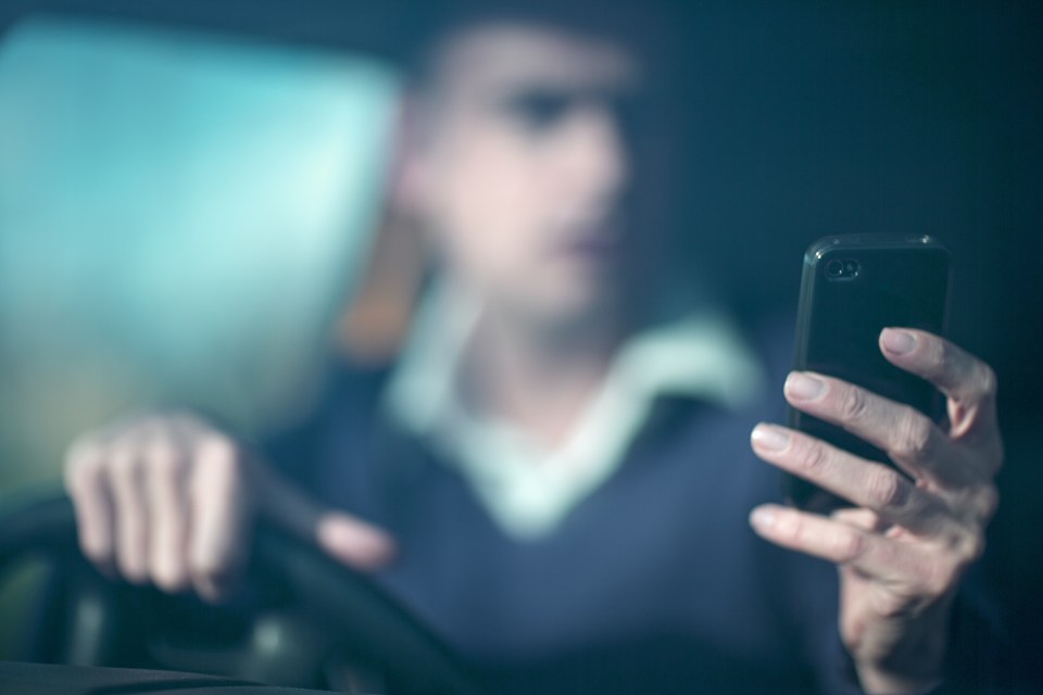Man using smartphone whilst driving