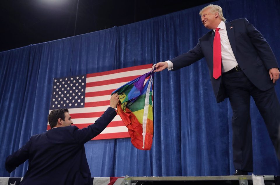 Trump returns the rainbow flag to an aide at the event in Colorado 