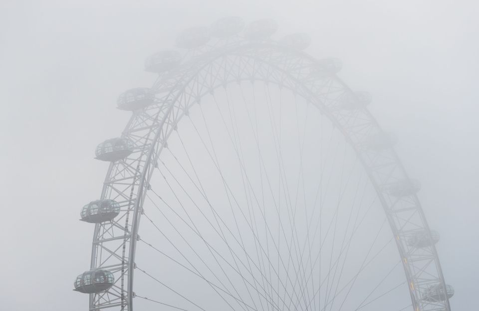 The London Eye is seen through thick fog