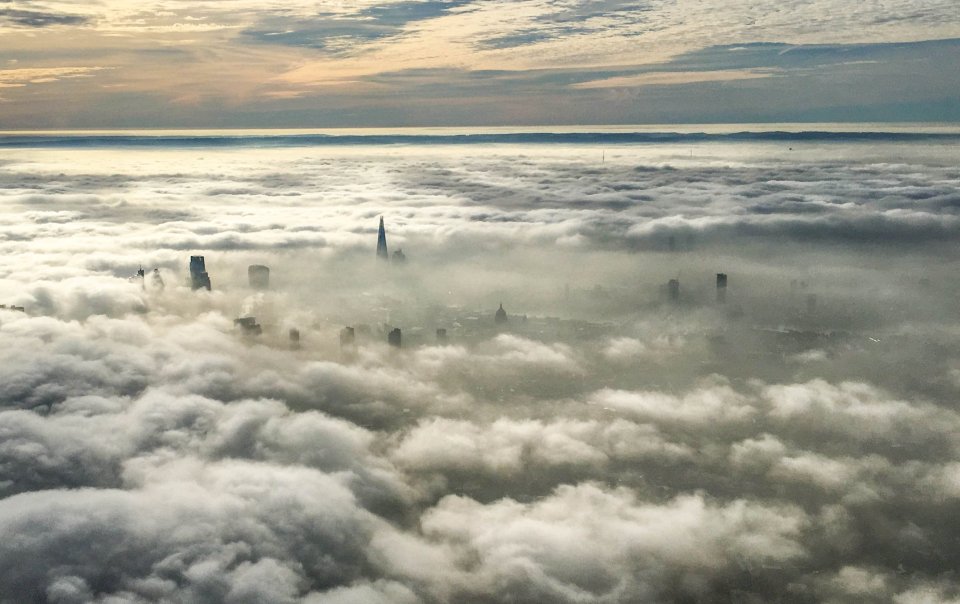 London's tallest buildings poke through low cloud and fog as seen a helicopter this morning