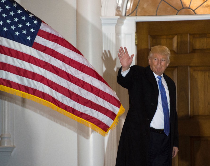 President-elect Donald Trump waves to the media from the steps at the clubhouse of Trump National Golf Club