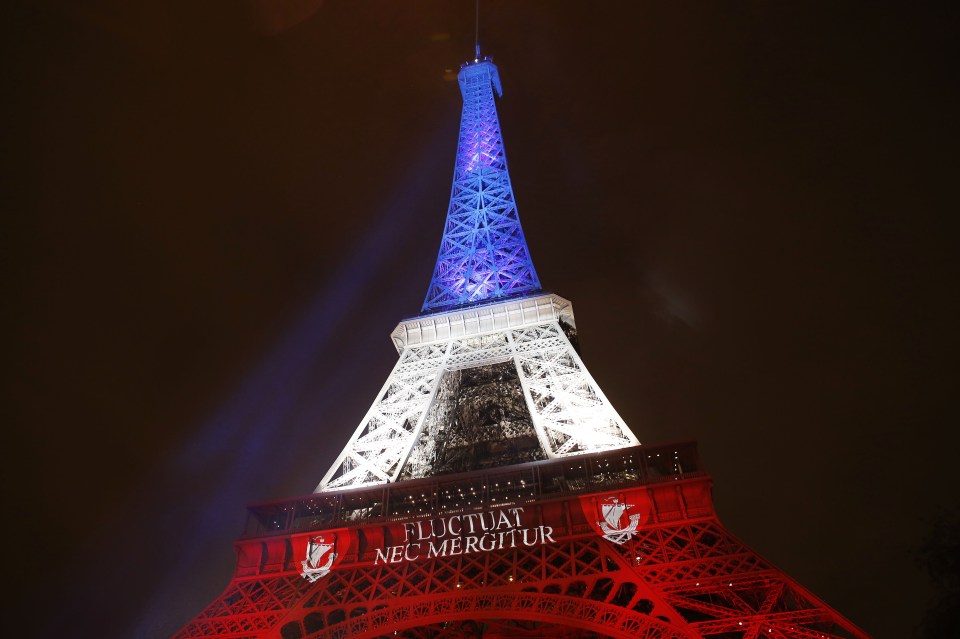 The illuminated Eiffel Tower shines in the bright colours of the French national flag, following the terror attacks