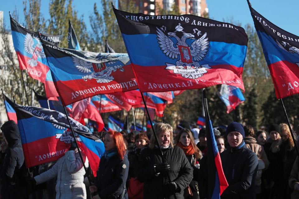 People hold flags of the Donetsk People's Republic during Flag Day celebrations in Lenin Square a fortnight ago