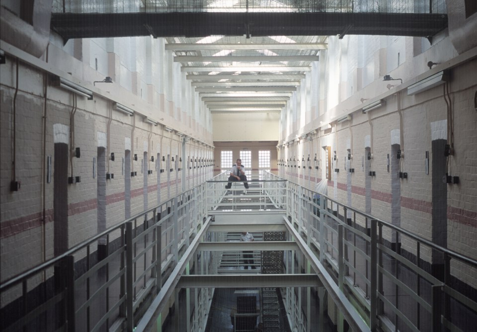 A lone prison officer on a prison wing at Winchester Prison, UK.. Image shot 2000. Exact date unknown.