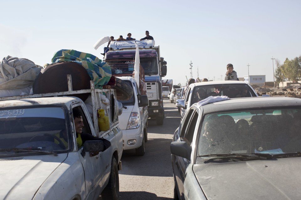 Cars streaming out of Mosul to head for the village of Bazwaya 8km away