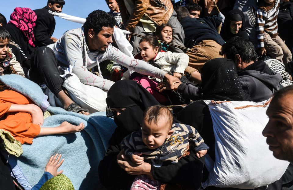 Freed civilians rush to clamber onboard a truck to take them out of Mosul to safety