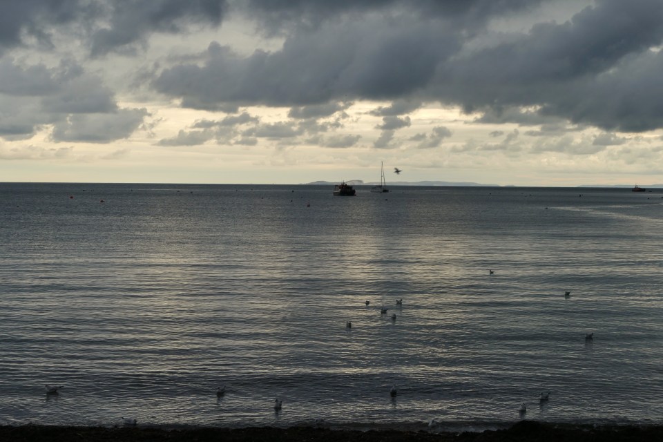 Dark grey rain clouds hover over Swanage Bay at first light this morning