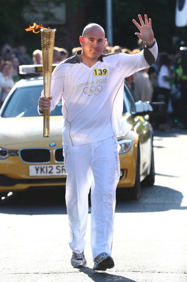 Simon Buckden holding the Olympic torch in 2012