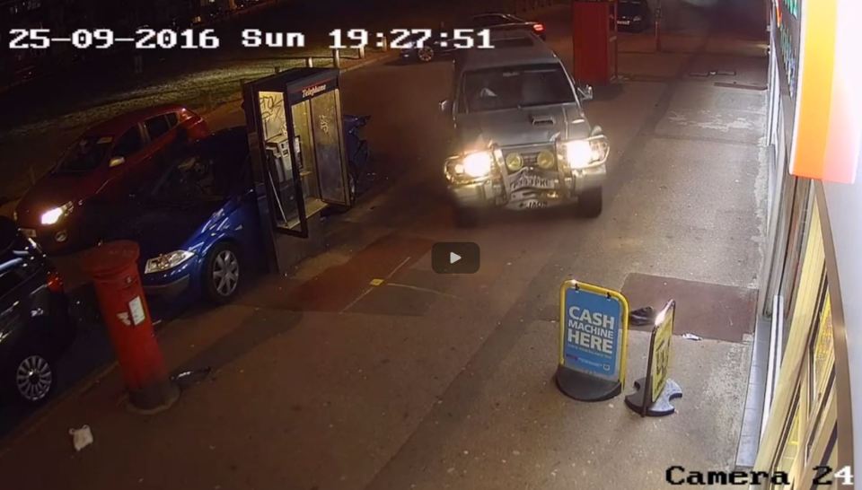 The car speeds past the wrecked vehicles on the pavement as the driver flees the scene