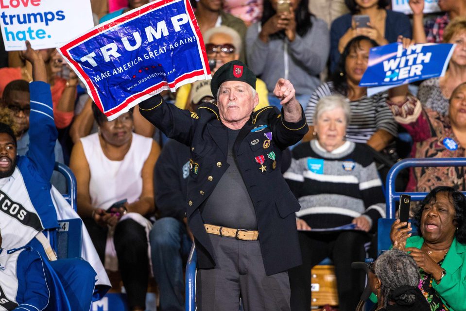 The pensioner in military attire stood up and held a pro-Trump banner as rally-goers booed him